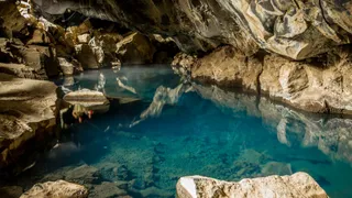 Grjótagjá cave on Iceland with clear, turquoise blue water