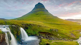 A must-see on the Island round trip is the Kirkjufell, the most famous mountain of Iceland, growing green beside a waterfall