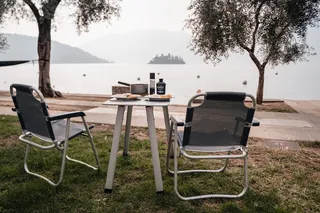 A camping set is in front of a camper.